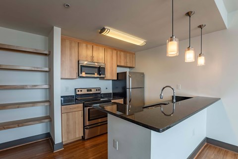 A kitchen with a black countertop and wooden cabinets.