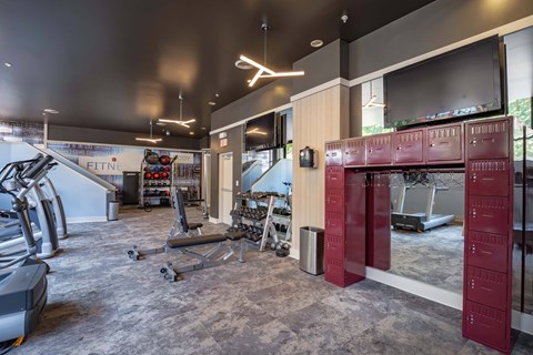 A gym with a variety of equipment including treadmills, weights, and exercise machines.