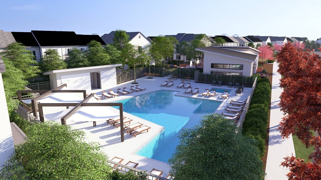 A large outdoor swimming pool surrounded by sun loungers and trees.