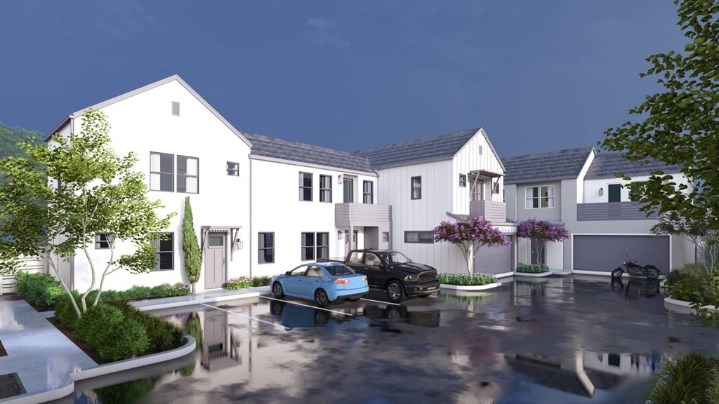 A white house with a black car parked in front.