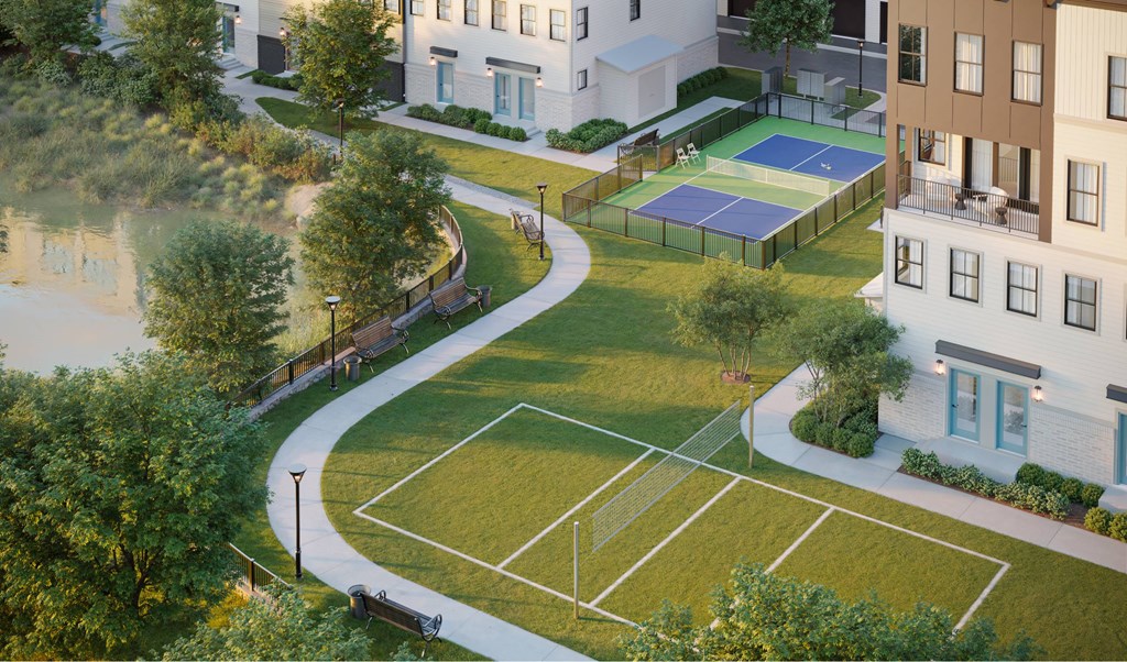A tennis court is surrounded by apartment buildings.