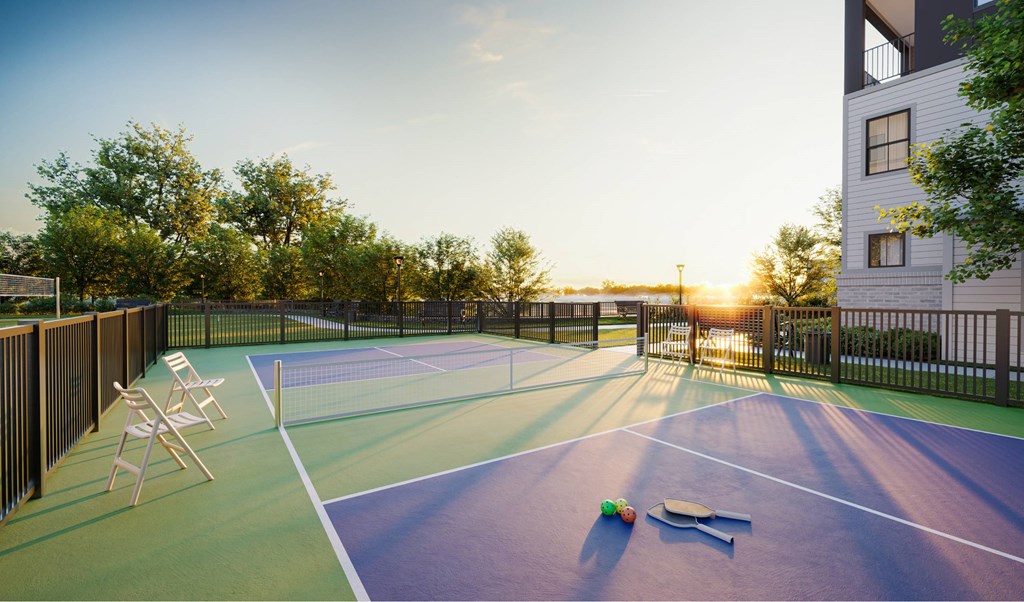 A tennis court with a net and two benches.