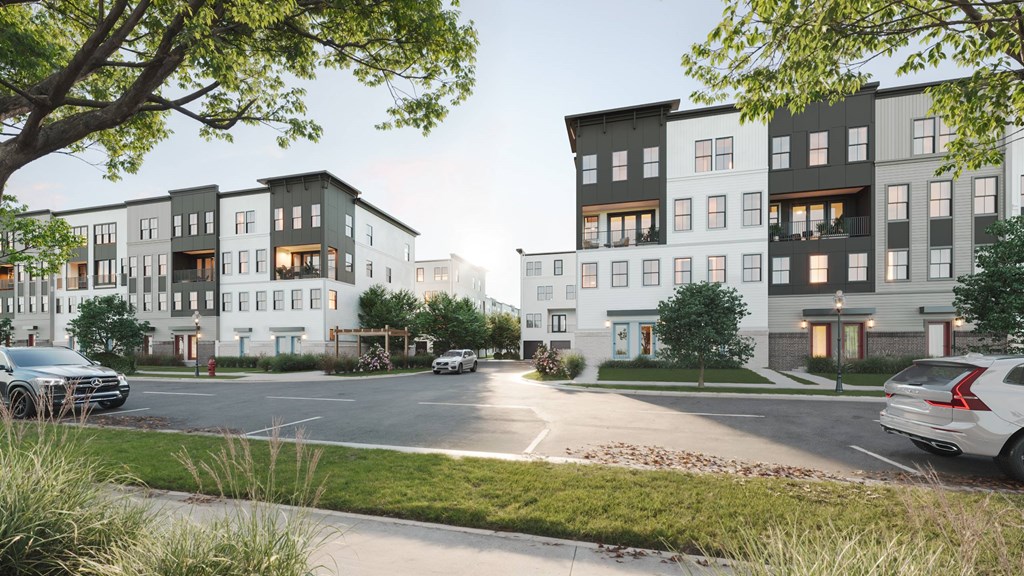 A modern apartment complex with cars parked in front.
