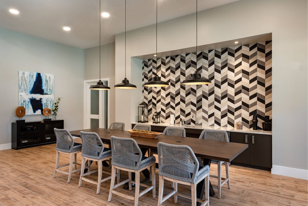 Community clubhouse with modern dining room with a wooden table and grey chairs at Brandywine Green, Maryland, 20613