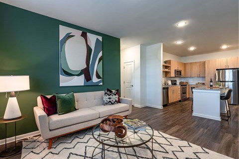 A living room with a white couch and a green wall.