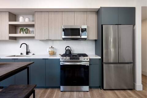 A modern kitchen with a stove top oven and a refrigerator.