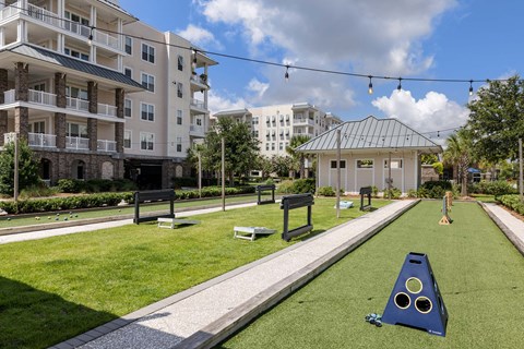 A playground with a slide and a ball pit in the foreground and apartment buildings in the background.