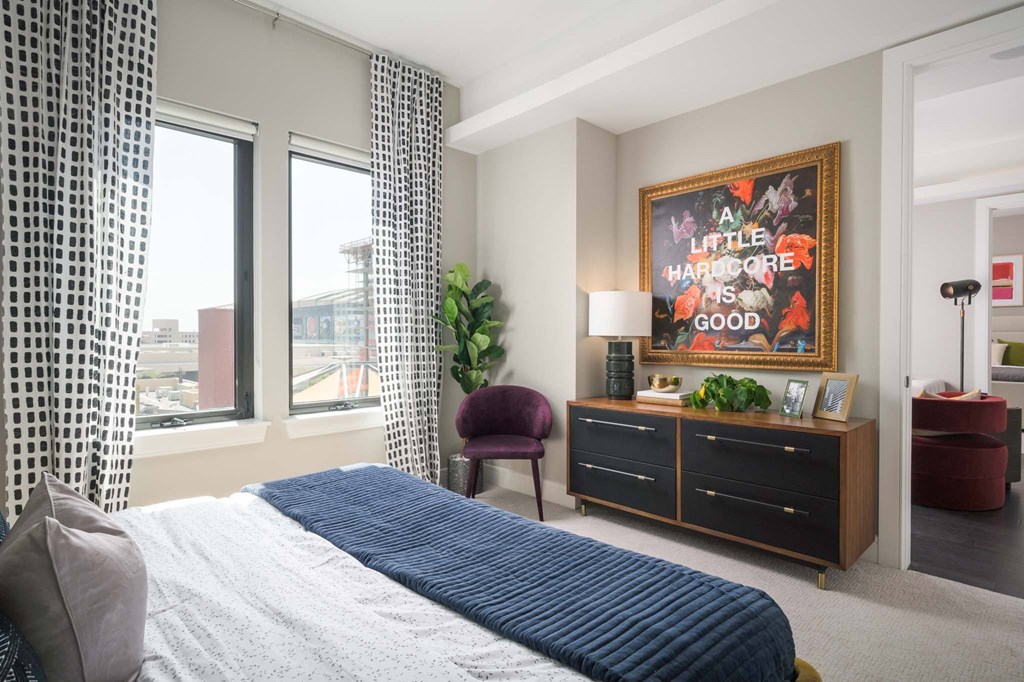 A bedroom with a large bed and a framed picture on the wall.