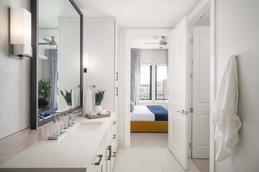 A bathroom with a white counter and a mirror above it.