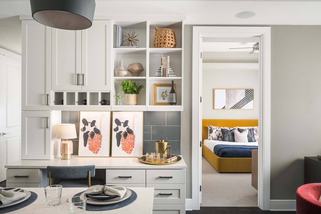 A modern kitchen with a dining table set for two.
