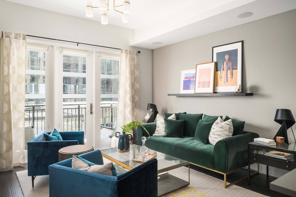 A living room with a green couch and a blue armchair.