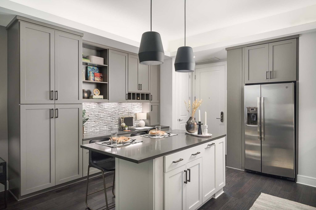 A modern kitchen with a large island and stainless steel appliances.
