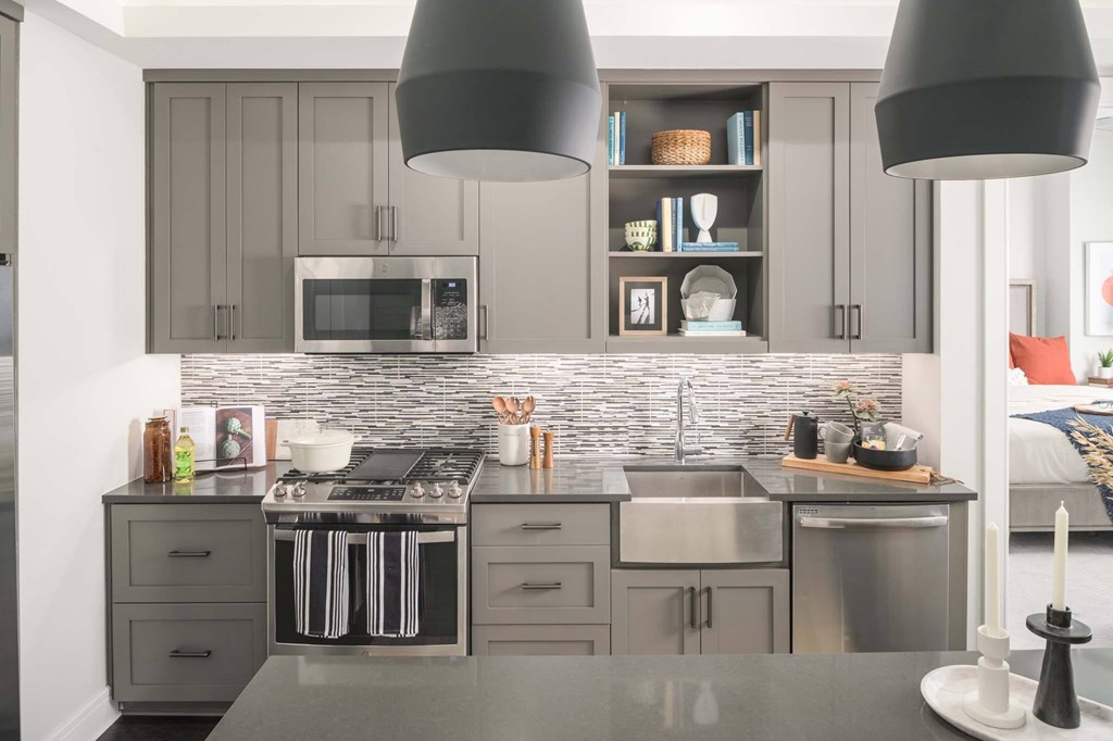 A modern kitchen with a grey countertop and grey cabinets.