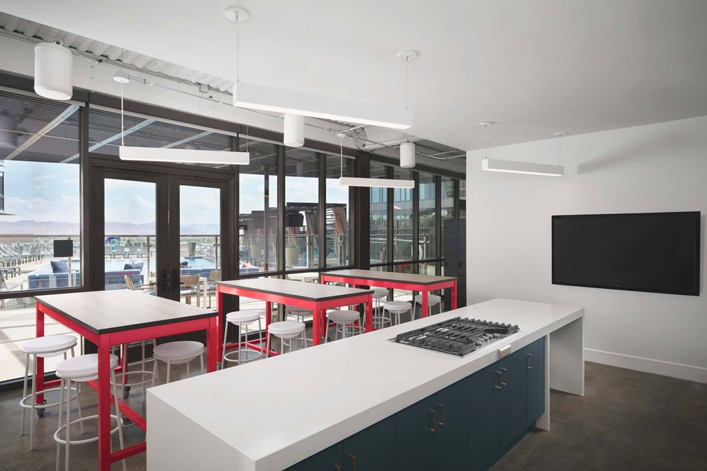 A modern kitchen with red stools and a large island.