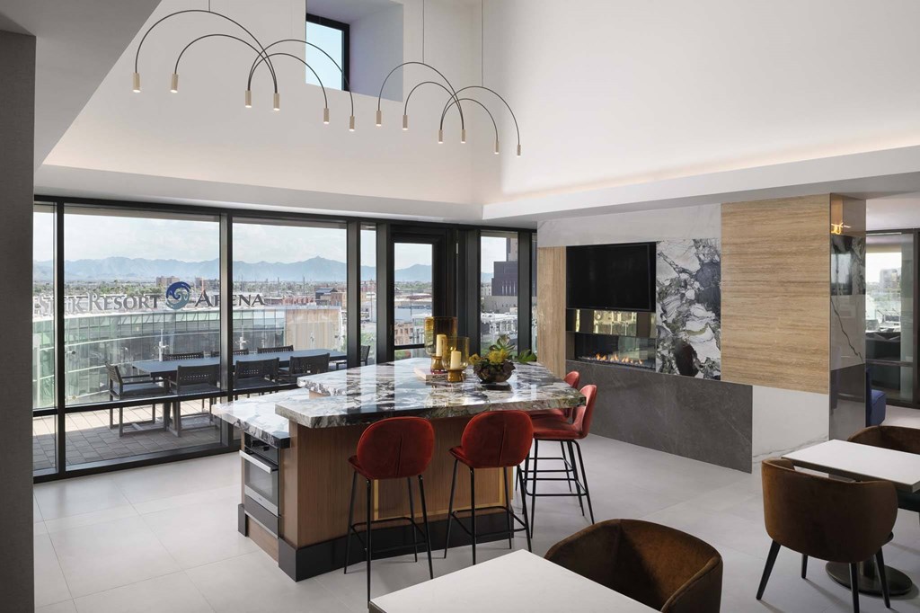 A modern kitchen with a large island and a view of the city.