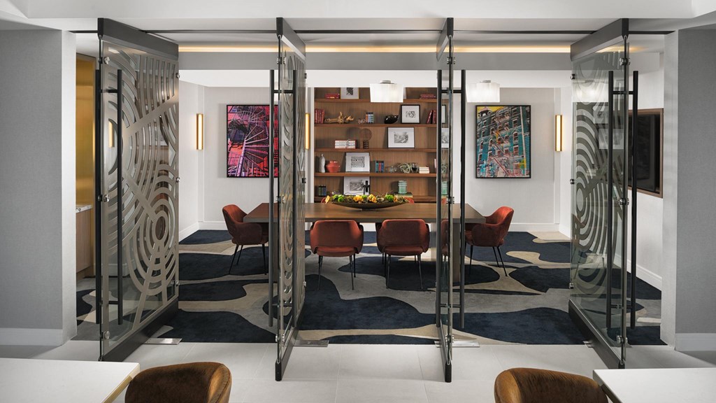 A modern room with a glass partition and a patterned rug.