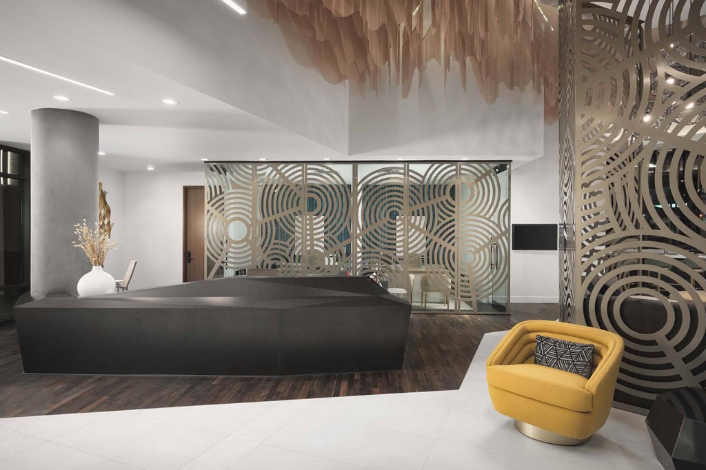 A modern room with a black sofa and a yellow chair.