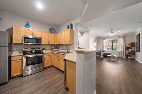 A kitchen with wooden cabinets and a stainless steel refrigerator.