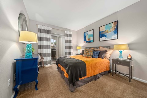 A bedroom with a bed, nightstands, and a chair.