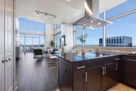 A modern kitchen with dark wood floors and a large island.