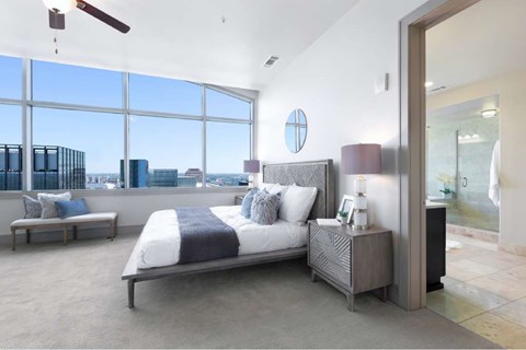 A bedroom with a large bed and a view of the city.