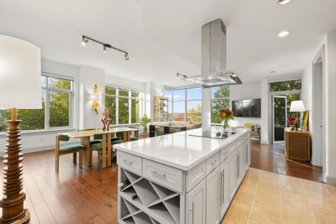 A modern kitchen with a large island and wooden floors.