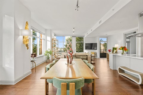 A dining room with a wooden table and green chairs.