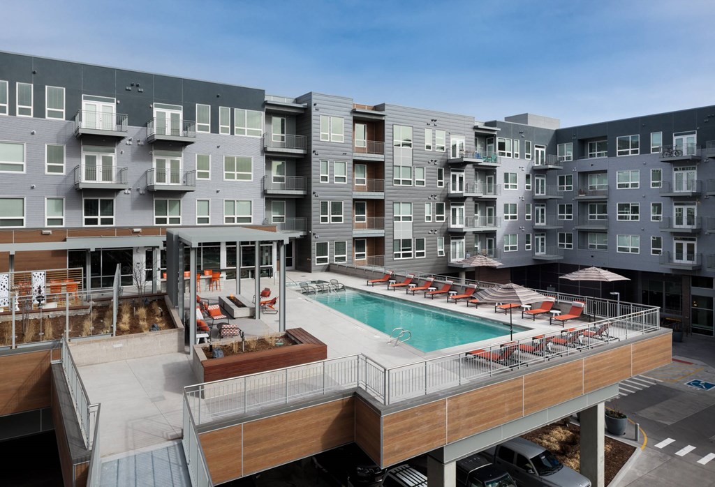 A large apartment complex with a pool and deck area.