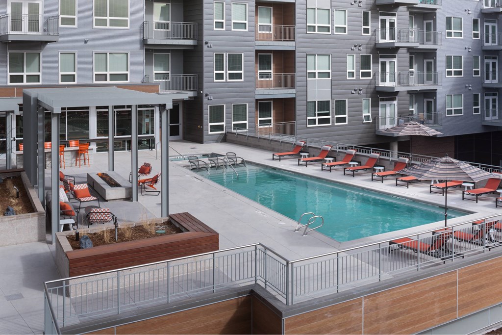 A pool area with a hot tub and lounge chairs.