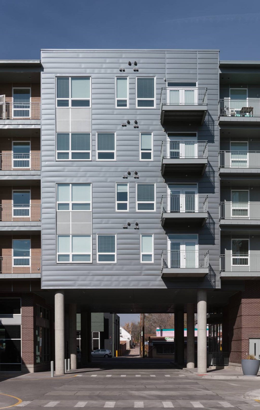 A modern apartment building with balconies and large windows.