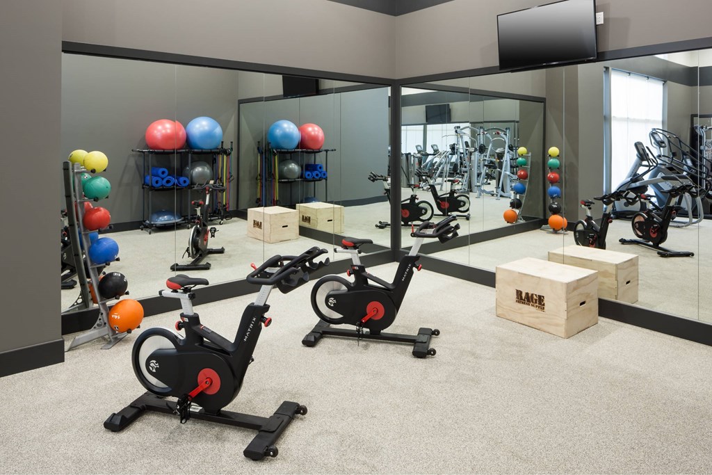 A gym with exercise equipment and a mirror.