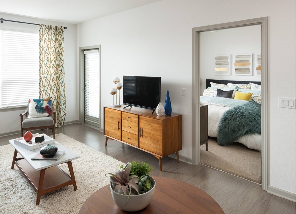 A living room with a wooden coffee table and a television on a cabinet.