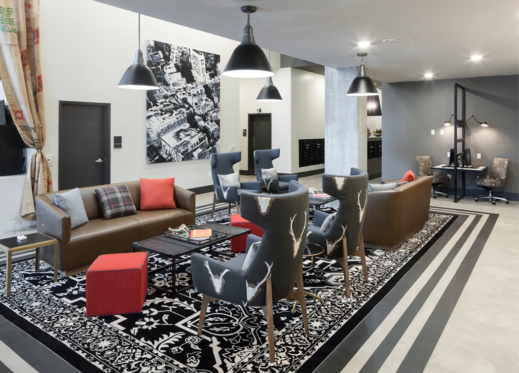 A living room with a black and white rug and a grey couch.