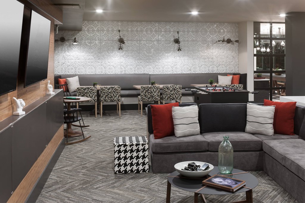 A modern living room with grey sofas and a patterned rug.