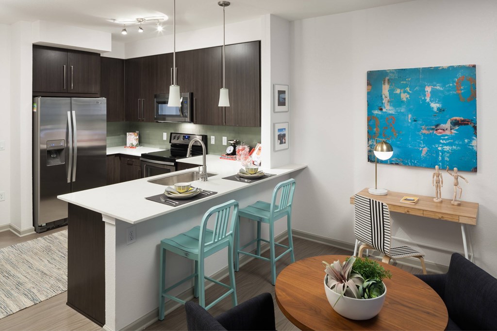 A kitchen with a white island and a blue chair.