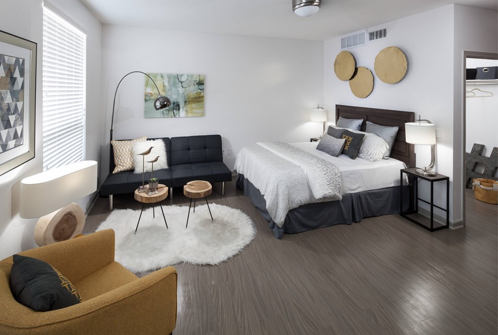 A modern bedroom with a large bed and a yellow armchair.