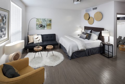 A modern bedroom with a large bed and a yellow armchair.