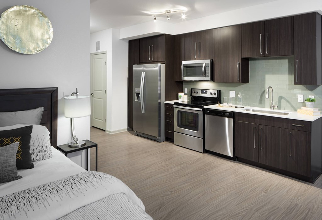 A modern kitchen with dark wood cabinets and stainless steel appliances.