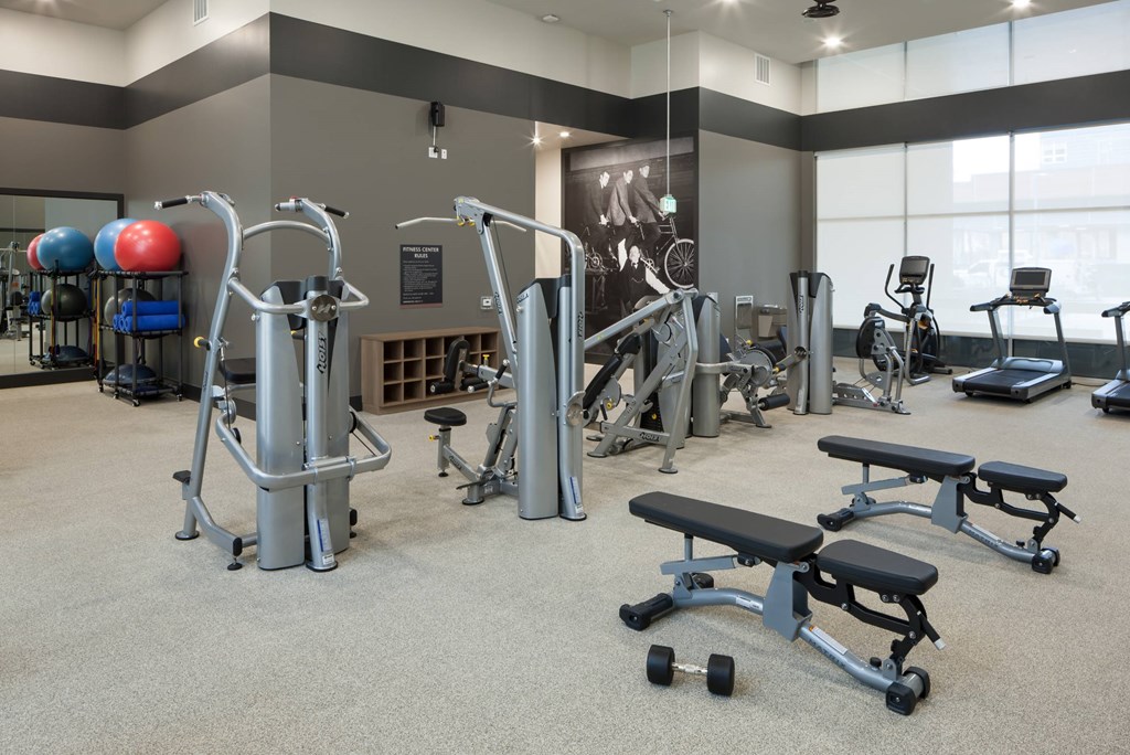 A gym with a variety of equipment including weights and benches.