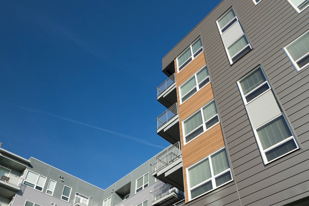 A modern apartment building with balconies and a clear blue sky.