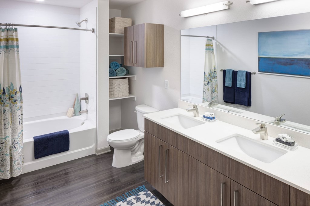 A bathroom with a toilet, sink, and shower.