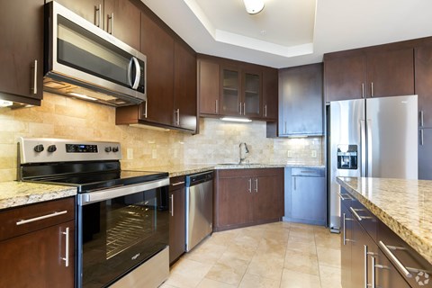 A kitchen with brown cabinets and stainless steel appliances.