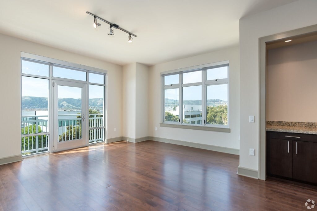 A spacious room with a view of the city through the windows.