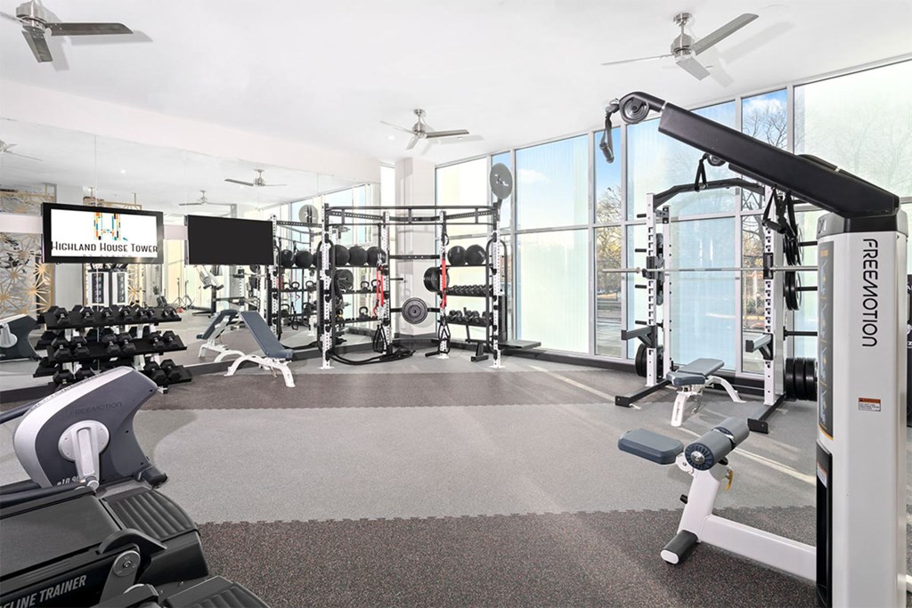 A gym with a variety of equipment including a rowing machine.