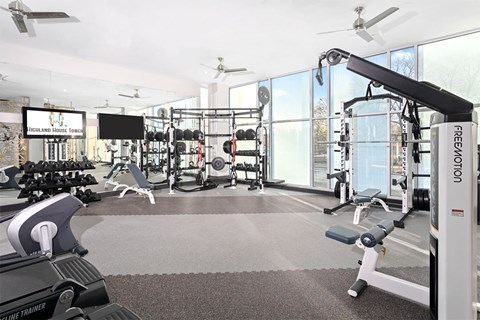 A gym with a variety of equipment including a rowing machine.