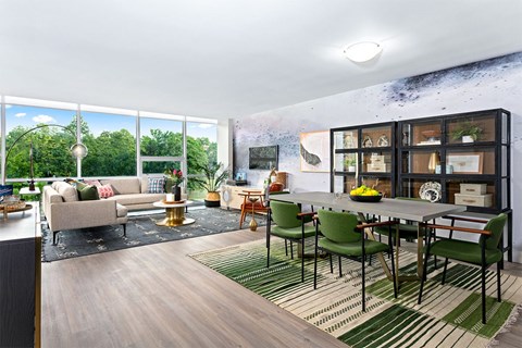 A modern living room with a large window overlooking a forest.