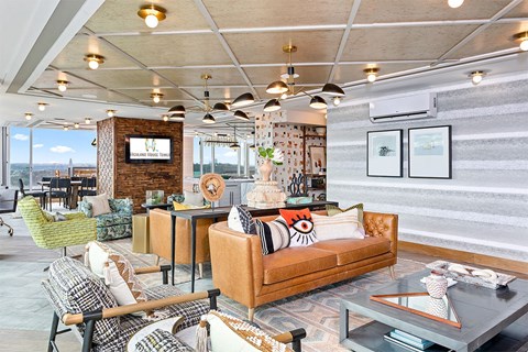 A living room with a couch, chairs, and a television.