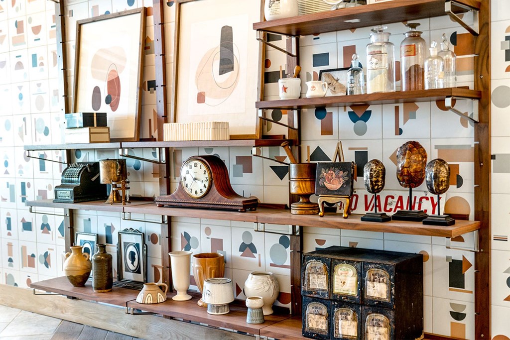 A shelf with a variety of objects including a clock, vases, and picture frames.