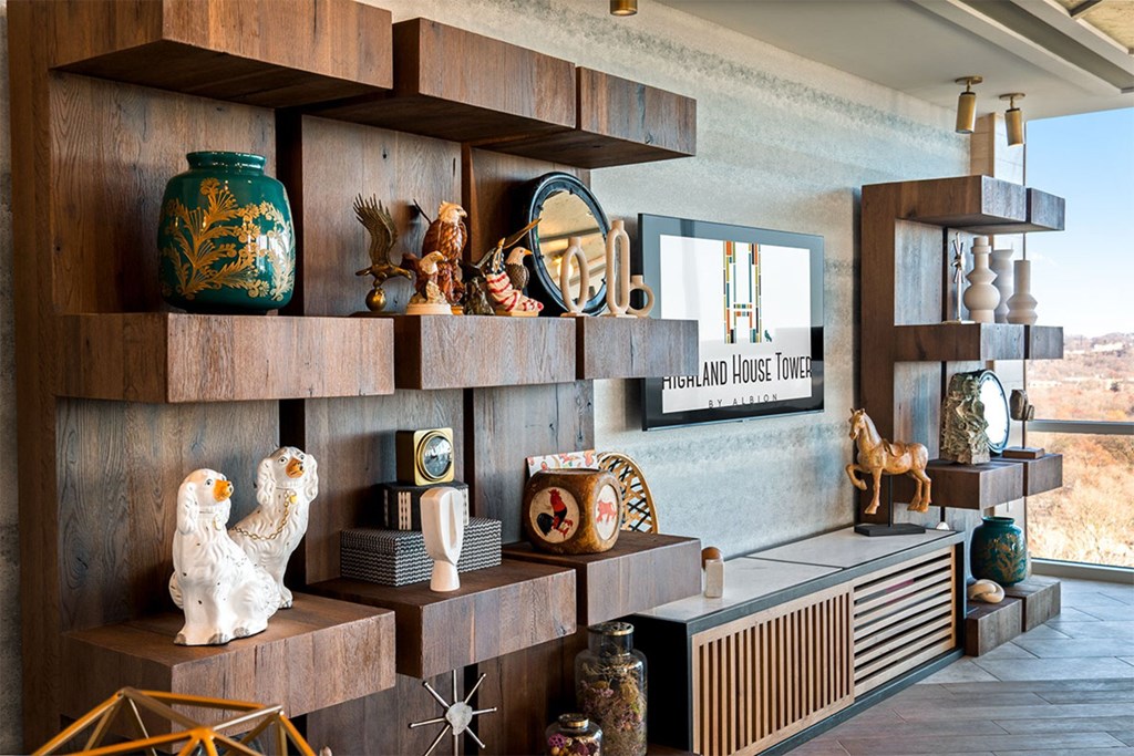 A shelf with various objects including a green vase and a white bird statue.