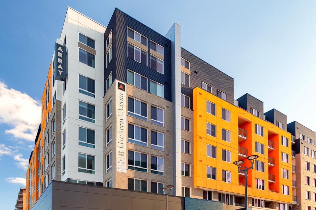 A modern building with a yellow and grey section in the foreground.